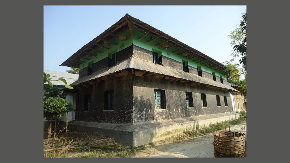 চিত্র: ০২। ছইঞ্চা যুক্ত দ্বি-তল ভবন, বাইরের ধারি পাকা এবং দেয়াল রং ও আলকাতরায় প্রলেপ করা। ২০১৫, মঙ্গলা, নওগাঁ।